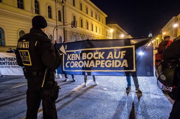 January 24, 2021, Munich, Bavaria, Germany: Antifascists and student protesters hold banners against Querdenken mentioning the relationship with Pegida. On the heels of a court win with the Verwaltungsgerichtshof, Markus Haintz of the Querdenken group organized an anti-mask, anti-anti-Corona measure demonstration in front of the Verwaltungsgerichtshof in Munich, Germany. Approximately 250 were in attendance and displayed a jump in radicalization and propensity for violence against media representatives not seen prior to the end of the Trump era. At one point, media representatives were swarmed, physically attacked and prevented from working as they were removed from the designated press area- with the help of their own conspiracy media r - ZUMAb160 20210124_zbp_b160_032 Copyright: xSachellexBabbarx