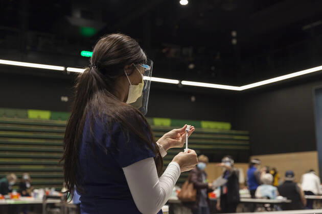 January 24, 2021, Seattle, Washington, USA: MARYAM MALLICK with Virginia Mason prepares to give an injection to a patient at a pop up COVID-19 vaccine clinic at the Amazon Headquarters in Seattle on Sunday, January 24, 2021. Amazon partnered with Virginia Mason Franciscan Health to vaccinate 2,000 Washingtonians who currently qualify to be vaccinated under the stateÃ¢â‚¬â ¢s COVID-19 Vaccine Phases guidelines. Seattle USA - ZUMAg235 20210124_zap_g235_017 Copyright: xPaulxChristianxGordonx