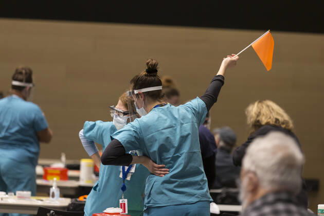 January 24, 2021, Seattle, Washington, USA: A medical worker waves a flag to notify the next patient at a pop up COVID-19 vaccine clinic at the Amazon Headquarters in Seattle on Sunday, January 24, 2021. Amazon partnered with Virginia Mason Franciscan Health to vaccinate 2,000 Washingtonians who currently qualify to be vaccinated under the stateÃ¢â‚¬â ¢s COVID-19 Vaccine Phases guidelines. Seattle USA - ZUMAg235 20210124_zap_g235_019 Copyright: xPaulxChristianxGordonx