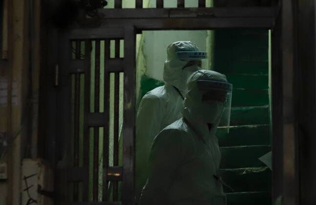 January 25, 2021, Hong Kong, CHINA: Government staffs post themselves inside the entrance of a building awaiting for residents to appear for Covid-19 checking before they are allowed to leave the restricted area. Hong Kong government have lifted partial lockdown in the City after 48 hours.Jan-25,2021Hong Kong.ZUMA Hong Kong CHINA - ZUMAl137 20210125_zap_l137_009 Copyright: xLiauxChung-renx