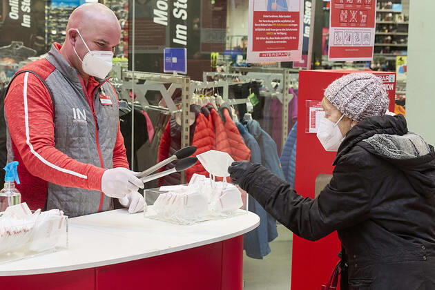 - Wien 25.01.2021 - Coronavirus Krise - FFP-Maskenpflicht - Als Konsequenz aus der weiteren Verbreitung des Coronavirus und den noch gefährlicheren Virusmutationen gilt ab heute die Pflicht FFP2 Masken in Supermärkten, in öffentlichen Verkehrmitteln, öffentlichen Gebäuden zu tragen. Die Supermarktketten verteilen je eine gratis FFP2 Maske pro Kunde für die ersten 3 Tage. Die Masken können auch für 0,59 Euro erworben werden. Österreich befindet sich noch bis vorraussichtlich den 8. Februar im 3., harten, Lockdown. PHOTO: Kunden und Angestellte dürfen nur mehr mit FFP2 Maske in den Supermarkt. Vienna, Austria - Corona virus crisis - FFP mask requirement - As a consequence of the further spread of the coronavirus and the even more dang 