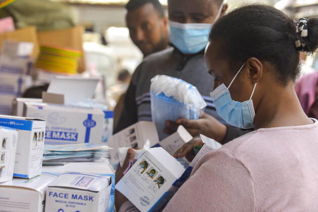 (210127) -- BEIJING, Jan. 27, 2021 -- A woman selects face masks at an open-air market in Addis Ababa, Ethiopia, Jan. 9, 2021. TO GO WITH XINHUA HEADLINES OF JAN. 27, 2021 ) WORLD-COVID-19-TOTAL CASES MichaelxTewelde 