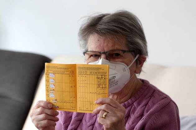Winden Themenbild - Coronavirus, Coronapandemie - Patientin einer Risikogruppe mit internationale Impfbescheinigung, Prophylaxebescheinigung, Impfpass, Impfbuch Themenbild - Coronavirus, Coronapandemie - Patientin einer Risikogruppe mit internationale Impfbescheinigung, Prophylaxebescheinigung, Impfpass, Impfbuch Coronavirus, Coronapandemie - Impfpass, Impfbuch, Impfbescheinigung, Impfdokument, internationale Impfbescheinigung, Prophylaxebescheinigung. Eine ältere Person, Rentnerin, einer Risikogruppe, mit 80 Jahren, sitzt in ihrem Wohnzimmer auf der Couch, Sofa und hält ihren gelben Impfpass für die bevorstehende Corona Schutzimpfung in der Hand, in den älteren, runzligen Fingern ihrer Händen. Model release Vertrag liegt vor. Model Copyright: xFleigx xEibner-Pressefotox EP_dfg