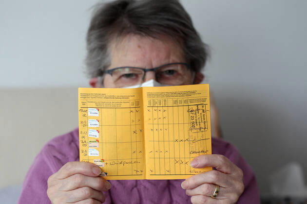 Winden Themenbild - Coronavirus, Coronapandemie - Patientin einer Risikogruppe mit internationale Impfbescheinigung, Prophylaxebescheinigung, Impfpass, Impfbuch Themenbild - Coronavirus, Coronapandemie - Patientin einer Risikogruppe mit internationale Impfbescheinigung, Prophylaxebescheinigung, Impfpass, Impfbuch Coronavirus, Coronapandemie - Impfpass, Impfbuch, Impfbescheinigung, Impfdokument, internationale Impfbescheinigung, Prophylaxebescheinigung. Eine ältere Person, Rentnerin, einer Risikogruppe, mit 80 Jahren, sitzt in ihrem Wohnzimmer auf der Couch, Sofa und hält ihren gelben Impfpass für die bevorstehende Corona Schutzimpfung in der Hand, in den älteren, runzligen Fingern ihrer Händen. Model release Vertrag liegt vor. Model Copyright: xFleigx xEibner-Pressefotox EP_dfg