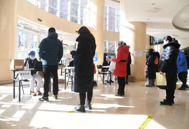 (210129) -- BEIJING, Jan. 29, 2021 -- Recipients wait for registration before the COVID-19 vaccination at a temporary vaccination site in Haidian District of Beijing, capital of China, Jan. 29, 2021. The administration of the second dose of COVID-19 vaccines for key groups of residents throughout Beijing started on Jan. 22, and is expected to conclude before Feb. 8. ) CHINA-BEIJING-COVID-19-VACCINATION-2ND-DOSE (CN) RenxChao 