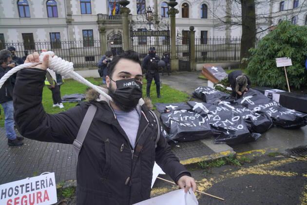 A worker in the hospitality sector demonstrates in front of the Xunta de Galicia with a rope tied around his neck as a sign of protest, in Santiago de Compostela, A Coruna, Galicia, Spain, January 29, 2021. The concentration occurs after a pilgrimage of protest by hoteliers of Pontevedra to Santiago due to the new restrictions imposed by the Xunta that forces the hospitality industry to close. The path, convened by the association of hoteliers Hoempo (Hosteleros de Pontevedra, Poio and Marin), has also been made by other hoteliers from different localities of Galicia. As they point out, the claims are not to ask to be allowed to open their businesses, but to demand financial aid and tax exemptions to help them overcome these weeks of closu Copyright: xÃlvaroxBallesterosx 3539422