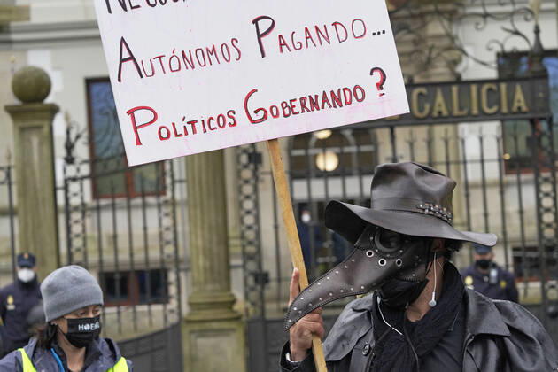 A worker of the hospitality sector demonstrates in front of the Xunta de Galicia holding a banner as a sign of protest, in Santiago de Compostela, A Coruna, Galicia, (Spain), January 29, 2021. The concentration comes after a pilgrimage of protest made by hoteliers of Pontevedra to Santiago due to the new restrictions imposed by the Xunta that forces the hospitality industry to close. The path, convened by the association of hoteliers Hoempo (Hosteleros de Pontevedra, Poio and Marin), has also been made by other hoteliers from different localities of Galicia. As they point out, the claims are not to ask to be allowed to open their businesses, but to demand financial aid and tax exemptions to help them overcome these weeks of closure. 29 JAN Copyright: xÃlvaroxBallesterosx 3539429