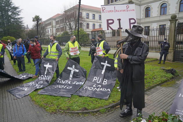 Workers of the hotel and catering sector hold tombstones made with paper in front of the Xunta de Galicia as a sign of protest, in Santiago de Compostela, A Coruna, Galicia, (Spain), January 29, 2021. The concentration occurs after a pilgrimage of protest made by hoteliers of Pontevedra to Santiago due to the new restrictions imposed by the Xunta that forces the hospitality industry to close. The path, convened by the association of hoteliers Hoempo (Hosteleros de Pontevedra, Poio and Marin), has also been made by other hoteliers from different localities of Galicia. As they point out, the claims are not to ask to be allowed to open their businesses, but to demand financial aid and tax exemptions to help them overcome these weeks of closur Copyright: xÃlvaroxBallesterosx 3539446