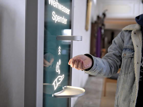 30.01.2021, Kirchen in Bayern, Corona-Regeln in einer Kirche in Bayern, EIn von der Mindelheimer Firma Elektro-Bauer neuentwickelter, Corona-Konformer Weihwasser-Spender mit berührungslosem Ultraschall-Bewegungs-Sensor sichert die Einhaltung der Hygienemassnahmen für die Gläubigen. Weihwasser kann man sich vom Automatischen Spender auf die Hand geben lassen. 30.01.2021, Kirche in Corona-Zeiten 30.01.2021, Kirche in Corona-Zeiten