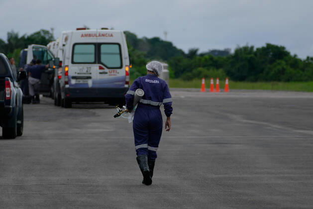MANAUS, AM - 30.01.2021: TRANSFERÊNCIA DE PACIENTES COVID EM MANAUS - Covid-19 patients are transferred from Manaus (AM) to Natal (RN), on the Brazilian Air Force (FAB) plane, this Saturday afternoon (30th), at Ponta Pelada Airport, in the south of the city. In the photo, a nurse carries an oxygen cylinder for an ambulance. x2026363x  SandroxPereira