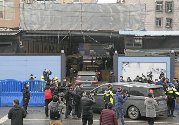 WHO probe into coronavirus origins in Wuhan A motorcade carrying members of the World Health Organization s team investigating the origins of the coronavirus pandemic enters the Huanan seafood wholesale market in Wuhan, China, on Jan. 31, 2021. 