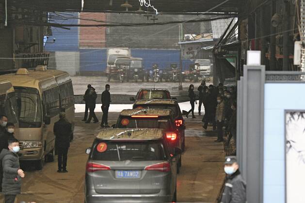 WHO probe into coronavirus origins in Wuhan A motorcade carrying members of the World Health Organization s team investigating the origins of the coronavirus pandemic enters the Huanan seafood wholesale market in Wuhan, China, on Jan. 31, 2021. 