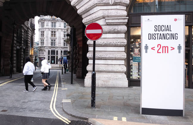 January 31, 2021, London, United Kingdom: Pedestrians walk past a social distancing sign on the street..Department of Health and Social Care recorded a total of 3,817,176 infections, 106,158 death and 1,673,936 recovered since the beginning of the outbreak. London United Kingdom - ZUMAs197 20210131_zaa_s197_176 Copyright: xMayxJamesx