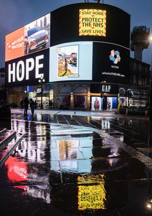 January 31, 2021, London, United Kingdom: Silhouette of pedestrians walking past a COVID-19 electronic billboard encouraging people to stay home, protect the NHS, save lives..Department of Health and Social Care recorded a total of 3,817,176 infections, 106,158 death and 1,673,936 recovered since the beginning of the outbreak. London United Kingdom - ZUMAs197 20210131_zaa_s197_180 Copyright: xMayxJamesx