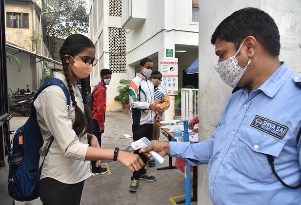(210201) -- HYDERABAD, Feb. 1, 2021 -- A student gets her body temperature measured before entering a school after a gap of almost a year following COVID-19 guidelines in Hyderabad, capital of India s southern state of Telengana on Feb. 1, 2021. (Str Xinhua) INDIA-HYDERABAD-SCHOOL REOPENS ParthaxSarkar 