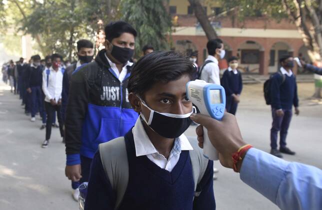 GURUGRAM, INDIA - FEBRUARY 1: A student undergoes thermal screening before entering Model Senior Secondary School Urban Estate at Sector 4, on February 1, 2021 in Gurugram, India. Schools in Gurugram reopened for 6th to 8th standard today. (Photo by Vipin Kumar Hindustan Times) Daily Life Amid Covid-19 Pandemic In India