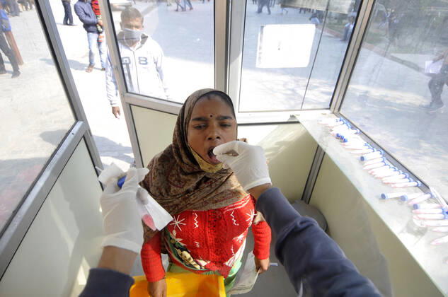 NOIDA, INDIA - FEBRUARY 1: A health worker collects a swab sample from a woman for Covid-19 test, at Sector 30 District Hospital, on February 1, 2021 in Noida, India. (Photo by Sunil Ghosh Hindustan Times) Daily Life Amid Covid-19 Pandemic In India