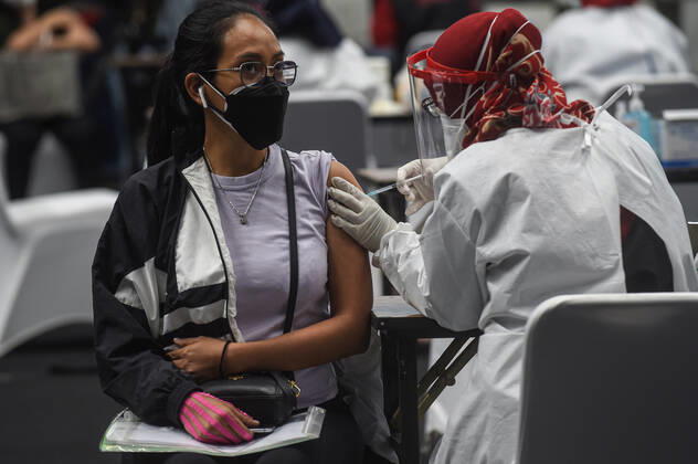 (210204) -- JAKARTA, Feb. 4, 2021 -- A health worker (L) receives a dose of China s Sinovac COVID-19 vaccine during mass vaccination program for health workers as a main priority group in Jakarta, Indonesia, Feb. 4, 2021. ) INDONESIA-JAKARTA-MASS VACCINATION PROGRAM-COVID-19 AgungxKuncahyaxB. 