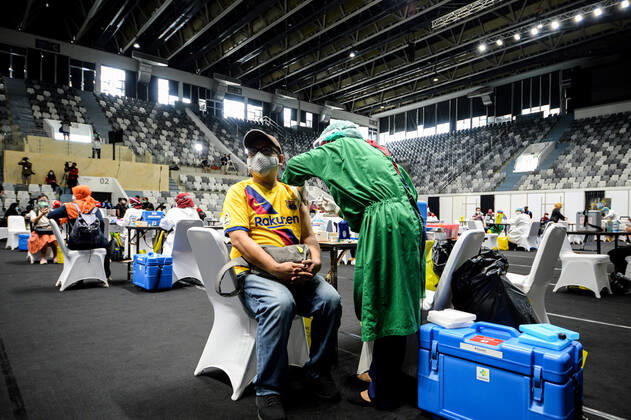 (210204) -- JAKARTA, Feb. 4, 2021 -- A health worker (L) receives a dose of China s Sinovac COVID-19 vaccine during mass vaccination program for health workers as a main priority group in Jakarta, Indonesia, Feb. 4, 2021. ) INDONESIA-JAKARTA-MASS VACCINATION PROGRAM-COVID-19 AgungxKuncahyaxB. 
