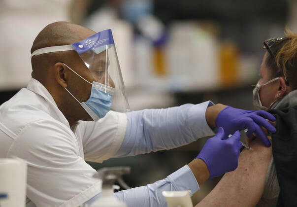 A health care worker administers the coronavirus vaccine to a school staff member in Medina, Ohio, Thursday, February 4, 2021.  CLE20200204103 AARONxJOSEFCZYK