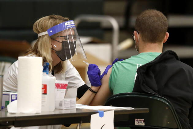 A health care worker administers the coronavirus vaccine to a school staff member in Medina, Ohio, Thursday, February 4, 2021.  CLE20200204104 AARONxJOSEFCZYK