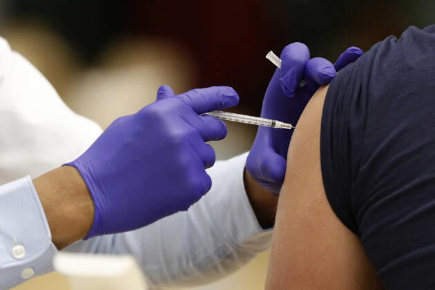 A health care worker administers the coronavirus vaccine to a school staff member in Medina, Ohio, Thursday, February 4, 2021.  CLE20200204106 AARONxJOSEFCZYK