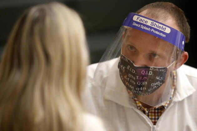 A health care worker talks to a school staff teacher after administering the Pfizer coronavirus vaccine in Medina, Ohio, Thursday, February 4, 2021.  CLE202002041108 AARONxJOSEFCZYK