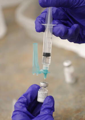 A health care worker prepares a Pfizer coronavirus vaccine for school staff members in Medina, Ohio, Thursday, February 4, 2021.  CLE20200204113 AARONxJOSEFCZYK