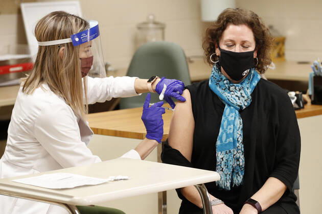 A health care worker administers the Pfizer coronavirus vaccine to a middle school teacher in Medina, Ohio, Thursday, February 4, 2021.  CLE20200204114 AARONxJOSEFCZYK