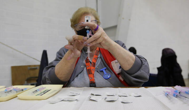 A health care worker prepares a Moderna coronavirus vaccine in Medina, Ohio, Thursday, February 4, 2021.  CLE20200204124 AARONxJOSEFCZYK