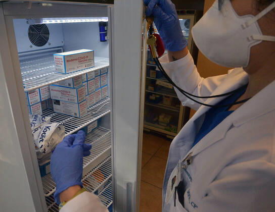 A physician assistant retrieves a box of the Moderna vaccine at the Kedren Community Health Center in Los Angeles on Thursday, February 4, 2021. Seniors 65 and older can now move to the head of the line to receive their vaccinations without an appointment. Abraham and his team at Kedren have pioneered workarounds to ensure that the people in South L.A. who need the vaccine the most , healthcare workers and those over 65 can get it.  LAP2021020415 JIMxRUYMEN