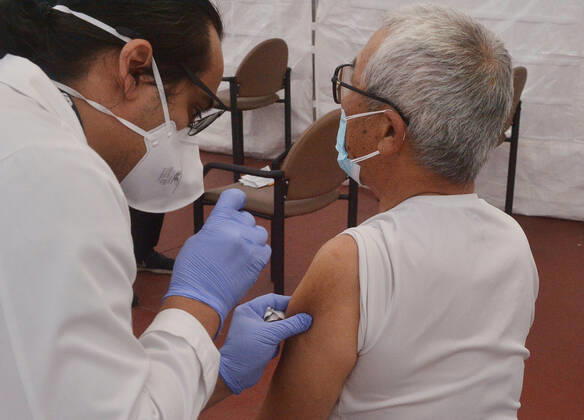 A nurse inoculates a senior citizen with the Moderna COVID-19 vaccine at the Kedren Community Health Center in Los Angeles on Thursday, February 4, 2021. Seniors 65 and older can now move to the head of the line to receive their vaccinations without an appointment. Director Jerry Abraham and his team at Kedren have pioneered workarounds to ensure that the people in South L.A. who need the vaccine the most , healthcare workers and those over 65 can get it.  LAP2021020435 JIMxRUYMEN