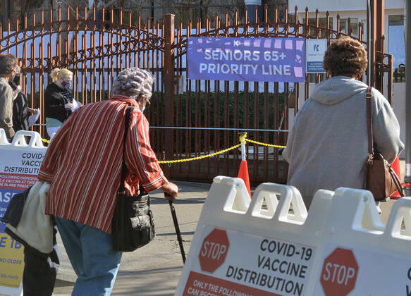Residents wait in line to receive COVID-19 leftover doses of the Moderna vaccine at the Kedren Community Health Center in Los Angeles on Thursday, February 4, 2021. Seniors 65 and older can now move to the head of the line to receive their vaccinations without an appointment. Director Jerry Abraham and his team at Kedren have pioneered workarounds to ensure that the people in South L.A. who need the vaccine the most , healthcare workers and those over 65 can get it.  LAP2021020408 JIMxRUYMEN