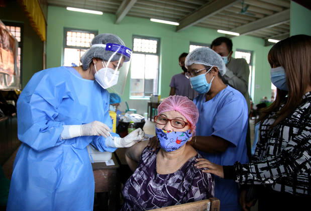 (210205) -- YANGON, Feb. 5, 2021 -- A woman receives the COVID-19 vaccine at a school in Yangon, Myanmar, Feb. 5, 2021. Myanmar resumed the vaccination program against COVID-19 across the country on Friday, according to an announcement from the Health and Sports Ministry. (Photo by Xinhua) MYANMAR-VACCINATION-COVID-19-RESUMPTION Haymhan 