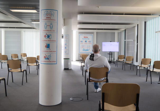 Bereich zur Nachbeobachtung, eine geimpfte Person sitzt auf einem Stuhl während einer 15-minütigen Ruhezeit; Bayerisches Impfzentrum Augsburg, Presseführung; Bayerisches Impfzentrum Augsburg, Presseführung;