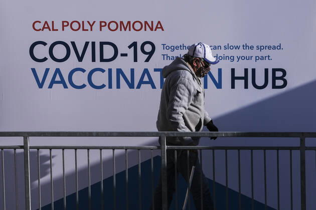 February 5, 2021, Los Angeles, California, USA: A senior resident walks by a poster at a mass COVID-19 vaccination site at Cal Poly Pomona, Friday Feb. 5, 2021 in Pomona, California. Los Angeles USA - ZUMAc68_ 20210205_zaf_c68_005 Copyright: xRingoxChiux