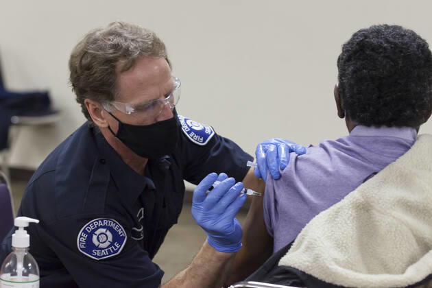 February 5, 2021, Seattle, Washington, USA: DANIEL CLARK, a member of the Seattle Fire Department, administers a dose of the Moderna COVID-19 vaccine to a patient at the Ethiopian Community of Seattle in the Rainier Valley on Friday, February 5, 2021. To date, the Seattle Fire Department Mobile Vaccination Teams have vaccinated 2,436 vulnerable Seattle residents and workers since launching its vaccination effort on January 14, 2021. Seattle USA - ZUMAg235 20210205_zap_g235_016 Copyright: xPaulxChristianxGordonx