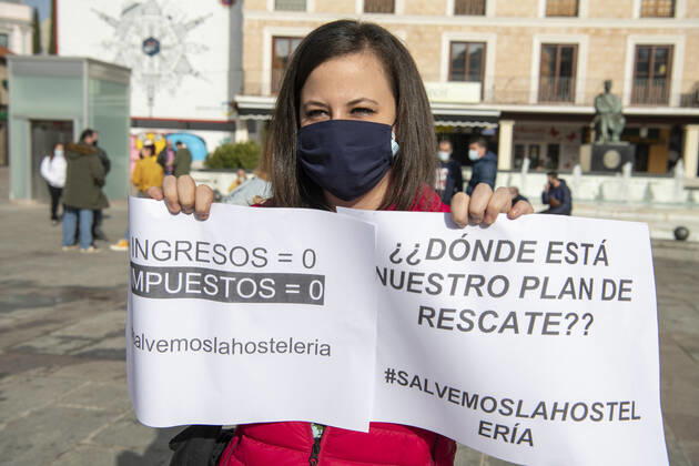 A woman belonging to the hospitality sector holds two posters in the Plaza Mayor Ciudad Real, in Ciudad Real, Castilla-La Mancha, (Spain), February 5, 2021. With the slogan, Let s save the hotel and catering industry , hoteliers have rallied to demand a change in the measures imposed on the sector by the Covid-19 health crisis. This comes a day after the meeting of the president of the Popular Party of Castilla-La Mancha with the president of the Community of Madrid who has claimed the head of the regional executive, the immediate opening of the hospitality industry in Castilla-La Mancha, with a model similar to that of the Community of Madrid . According to him, it is important to bet for the use of the mask, the respect of the social d Copyright: xEusebioxGarciaxdelxCastillox 3549386