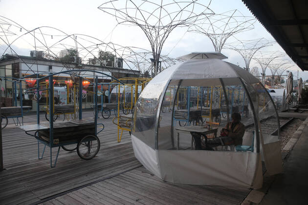 (210205) -- JERUSALEM, Feb. 5, 2021 -- A man sits in an outdoor dining bubble amid the COVID-19 pandemic in Jerusalem, on Feb. 5, 2021. (Photo by Xinhua) MIDEAST-JERUSALEM-COVID-19-DINING BUBBLE MuammarxAwad 