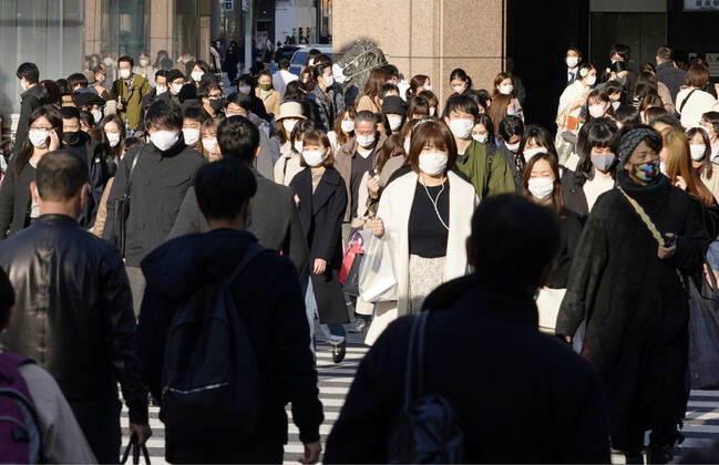 New coronavirus in Japan People wearing face masks walk in Tokyo s Ginza area on Feb. 7, 2021, amid the coronavirus pandemic. 
