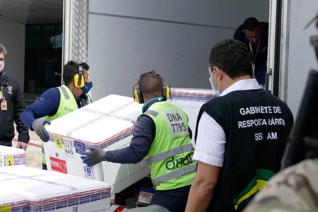 MANAUS, AM - 07.02.2021: MAIS DE 96 MIL VACINAS CHEGAM EM MANAUS - Arrival of over 96,200 doses of the CoronaVac immunizer, at Eduardo Gomes International Airport in Manaus (AM), this Sunday morning (07). In an information note from the Ministry of Health, of the total doses destined for Amazonas, part is related to the Vaccination Operationalization Plan against Covid-19. Another part is the Strategic Fund created with 5% of the total vaccines, used to attend the most serious priority cases of the pandemic and that, at this moment, benefits the Amazon. In the photo, Governor Wilson Lima, from behind, monitors the unloading of vaccines. x2029552x SandroxPereira