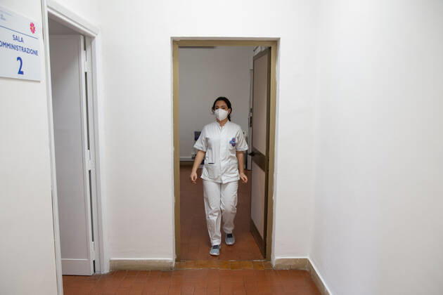 Italy: First COVID-19 vaccination for people over 80 in Rome Nurse goes into vaccination room Rome Italy Copyright: MatteoxNardone