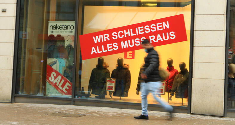 Im Schaufenster eines während des Lockdowns geschlossenen Bekleidungsgeschäfts klebt ein Aufkleber, der darauf hinweist, dass wegen der Geschäftsaufgabe ein Räumungsverkauf ansteht. Innenstadt Hamburg