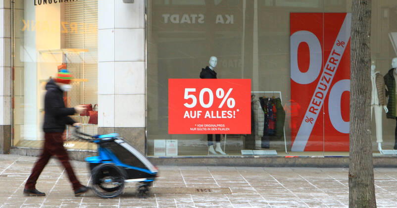 Im Schaufenster eines während des Lockdowns geschlossenen Einzelhandelgeschäfts klebt ein Aufkleber, der auf Rabatt-Aktionen hinweist. Innenstadt Hamburg