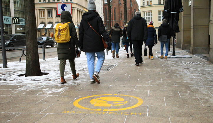 Auf den Gehwegplatten in der Hamburger Innenstadt ist ein Hinweis gesprüht, dass Maskenpflicht besteht. Innenstadt Hamburg