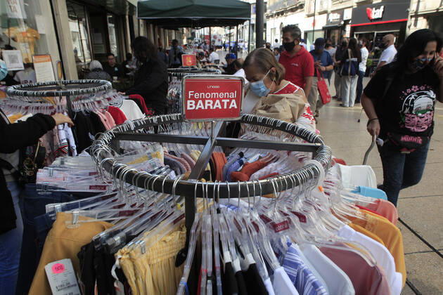 February 9, 2021, Mexico City, Mexico City, Mexico: A person looks clothes of a store that offer their outside service, after closed several days due red alert by Covid. The Mexican Government allowed the reopening of stores, some shops make outside sell to prevent crowd of people, as an attempt to prevent spread of the Virus February 9, 2021 in Mexico City, Mexico Mexico City Mexico - ZUMAe321 20210209_zia_e321_026 Copyright: xAngelxMoralesxRizox