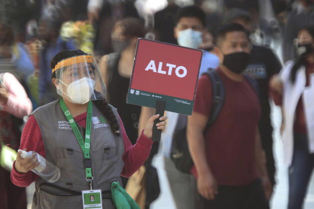 February 9, 2021, Mexico City, Mexico City, Mexico: A officer holds a sign to people follow the rules to prevent agglomerations. The Mexican Government allowed the reopening of stores, some shops make outside sell to prevent crowd of people, as an attempt to prevent spread of the Virus February 9, 2021 in Mexico City, Mexico Mexico City Mexico - ZUMAe321 20210209_zia_e321_029 Copyright: xAngelxMoralesxRizox