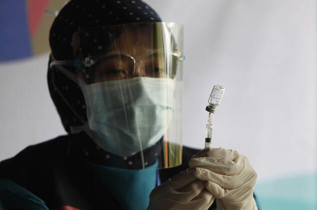 Indonesia s COVID-19 Mass Vaccination A health worker prepares a SinoVac COVID-19 vaccine during a mass vaccination for medical workers and elderly people in Bogor, West Java on February 11, 2021. (Photo by Adrian INA Photo Agency) 