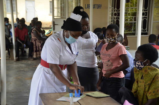 (210211) -- WAKISO, Feb. 11, 2021 -- A female nurse stamps documents at a health centre, Wakiso District in Central Uganda, Feb. 10, 2021. As the world commemorates International Day of Women and Girls in Science on Thursday, female scientists in Uganda are championing the fight against the COVID-19 pandemic. TO GO WITH Feature: Ugandan female scientists champion fight against COVID-19 (Photo by Xinhua) UGANDA-WAKISO-INTERNATIONAL DAY OF WOMEN AND GIRLS IN SCIENCE NicholasxKajoba 