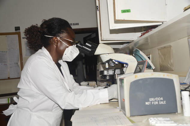 (210211) -- WAKISO, Feb. 11, 2021 -- Photo taken on Feb. 10, 2021 shows a female medical worker using a microscope at a health centre, Wakiso District in Central Uganda. As the world commemorates International Day of Women and Girls in Science on Thursday, female scientists in Uganda are championing the fight against the COVID-19 pandemic. TO GO WITH Feature: Ugandan female scientists champion fight against COVID-19 (Photo by Xinhua) UGANDA-WAKISO-INTERNATIONAL DAY OF WOMEN AND GIRLS IN SCIENCE NicholasxKajoba 